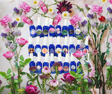 Load image into Gallery viewer, Enchanting Aura Sprays by Enchanting Flowers, natural essential oil fragrance mists in blue glass bottles, displayed with flowers